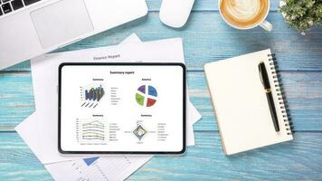tablette avec graphiques et rapports sur le lieu de travail de bureau. vue de dessus mise à plat photo