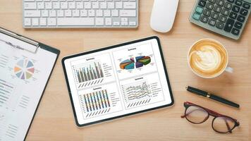 tablette avec graphiques et rapports sur le lieu de travail de bureau. vue de dessus mise à plat photo