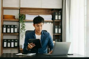 affaires homme exécutif directeur à la recherche à portable en train de regarder en ligne séminaire en ligne formation ou ayant virtuel réunion vidéo conférence Faire marché recherche travail dans bureau. photo