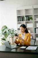 asiatique femme d'affaires travail dans le moderne Bureau avec travail bloc-notes, tablette et portable les documents photo