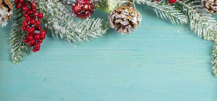 sur une turquoise bois arrière-plan, une décoration de une épicéa branche et cônes. Noël Contexte. photo