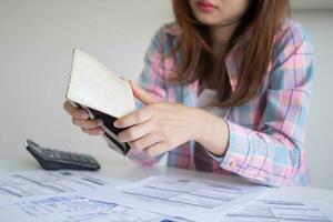 femme asiatique stressée et mal à la tête avec de grosses factures ou factures pas d'argent à payer pour les dépenses et la dette de carte de crédit. pénurie, problèmes financiers, hypothèque, prêt, faillite, faillite, pauvre, portefeuille vide photo