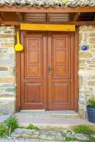une en bois double porte, avec foncé marron les fenêtres avec une pierre mur. photo