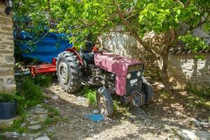 un vieux ferme tracteur, permanent dans le des buissons. photo