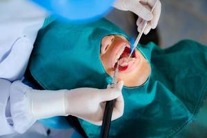 Femme dentiste debout dans le bureau de dentiste avec joint photopolymérisable photo