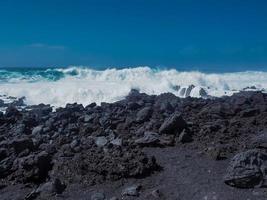 Vagues rencontrant la côte volcanique noire à el golfo lanzarote îles canaries photo