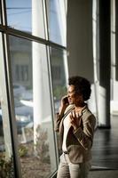 femme d & # 39; affaires au téléphone près de la fenêtre au bureau photo