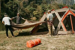 Jeune Hommes Aidez-moi ensemble en haut tentes pour camping. photo