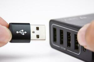USB une mise en charge câble dans main est bouchage dans une multi Port mobile téléphone chargeur. photo