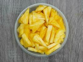 Haut vue de tranché Frais ananas dans une transparent récipient. en bonne santé nourriture et régime concept photo