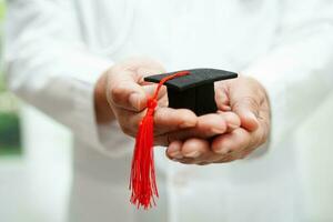 femme médecin asiatique tenant un chapeau de graduation à l'hôpital, concept d'éducation médicale. photo