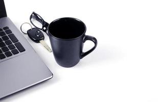 Tasse à café avec clé de voiture et lunettes sur fond blanc photo