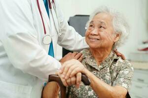 médecin Aidez-moi asiatique personnes âgées invalidité femme patient en portant en marchant bâton dans ridé main à hôpital. photo