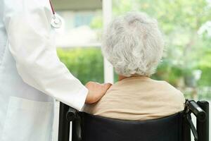 médecin Aidez-moi asiatique personnes âgées femme invalidité patient séance sur fauteuil roulant dans hôpital, médical concept. photo