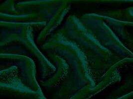 texture de tissu de velours vert utilisée comme arrière-plan. fond de tissu vert vide de matière textile douce et lisse. il y a de l'espace pour le texte. photo