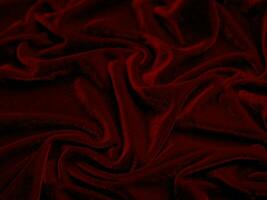 texture de tissu de velours rouge utilisée comme arrière-plan. fond de tissu rouge vide de matière textile douce et lisse. il y a de l'espace pour le texte.. photo