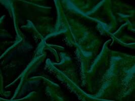 texture de tissu de velours vert utilisée comme arrière-plan. fond de tissu vert vide de matière textile douce et lisse. il y a de l'espace pour le texte. photo