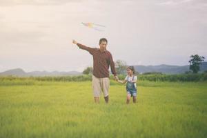 enfant et père jouant avec un cerf-volant dans le parc