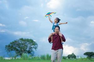 enfant et père jouant avec un cerf-volant dans le parc