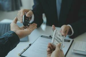 fermer asiatique Masculin gens voiture vendeur ou Ventes directeur des offres à vendre une voiture et explique et lit le termes de signature une voiture Contrat et assurance. photo