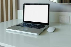 Maquette d'ordinateur portable et souris avec écran blanc sur table. photo
