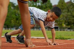 père et fils ont commencé à courir ensemble sur le tapis roulant. dans le concept de jeux de plein air, d'activités familiales, d'activités de plein air. mise au point douce et sélective. photo