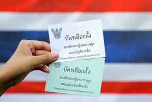 le scrutin papiers sont écrit dans thaïlandais, sens élection carte membres de le maison de représentants sur une circonscription électorale base et liste des partis proportionnel représentation sur thaïlandais drapeau Contexte. photo