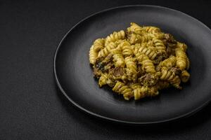 délicieux fusilli Pâtes avec vert Pesto sauce, avec sel et épices photo