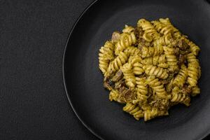 délicieux fusilli Pâtes avec vert Pesto sauce, avec sel et épices photo