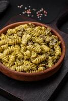 délicieux fusilli Pâtes avec vert Pesto sauce, avec sel et épices photo