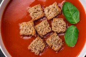 délicieux Frais Gaspacho avec chapelure, sel et épices dans une céramique assiette photo