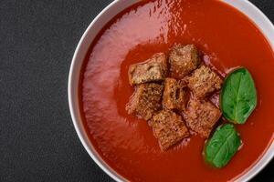 délicieux Frais Gaspacho avec chapelure, sel et épices dans une céramique assiette photo