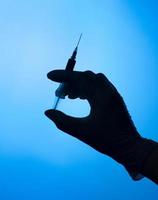 silhouette de main tenant coup de vaccin covid photo