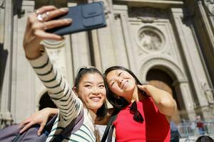 de bonne humeur asiatique femmes prise selfie contre historique bâtiment photo