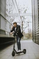 homme parlant au téléphone avec un scooter photo