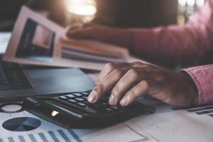 Concepts de comptabilité de comptable, homme utilisant la calculatrice pour calculer avec un stylo et un ordinateur portable pour travailler sur les finances et le budget, concept d'inspecteur comptable. photo