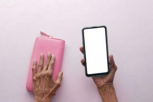 Haut vue de Sénior femmes en portant une intelligent téléphone avec vide écran photo