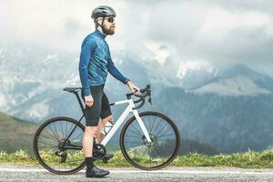 une Masculin cycliste sur le sien vélo observe le route il a à prendre photo