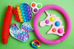 coloré anti stress sensoriel agiter jouets sur une vert Contexte. photo