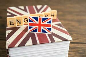 mot Anglais sur livre avec uni Royaume drapeau, apprentissage Anglais Langue cours concept. photo