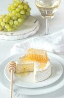 Camembert avec Miel, les raisins et blanc du vin photo