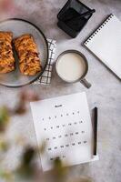 calendrier feuille pour Planification avec une tasse de café et petits pains dans fika temps Haut et verticale vue photo