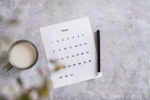 calendrier feuille pour Planification et une tasse de café avec Lait sur le table Haut vue photo