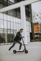 homme d & # 39; affaires occasionnel sur un scooter pour travailler photo