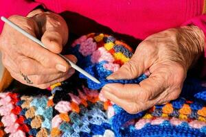 vieux femme avec tricot aiguilles et la laine photo