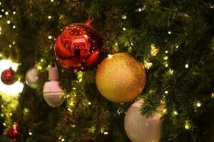 proche en haut décoration Balle et lumière ampoule sur Noël arbre à nuit photo