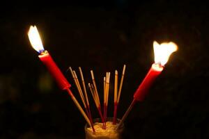 brûlant encens et rouge bougies à Payer hommage sur une foncé Contexte pendant faim fantôme Festival Payer hommage à leur décédé les ancêtres photo