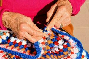 vieux femme avec tricot aiguilles et la laine photo