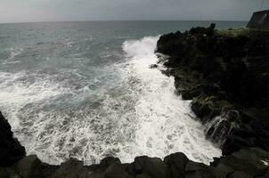 les vagues frappent les rochers photo