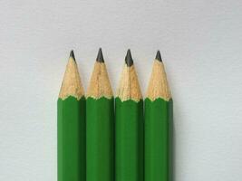 quatre crayons verts sur une feuille de papier photo